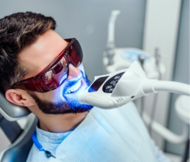 Man in dental chair getting his teeth professionally whitened