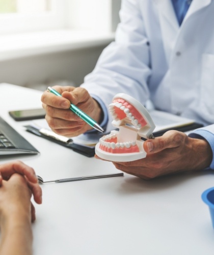 staff member showing patient a teeth model in Worcester